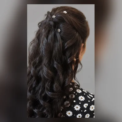 Dark curls dressed into a half-up occasion style